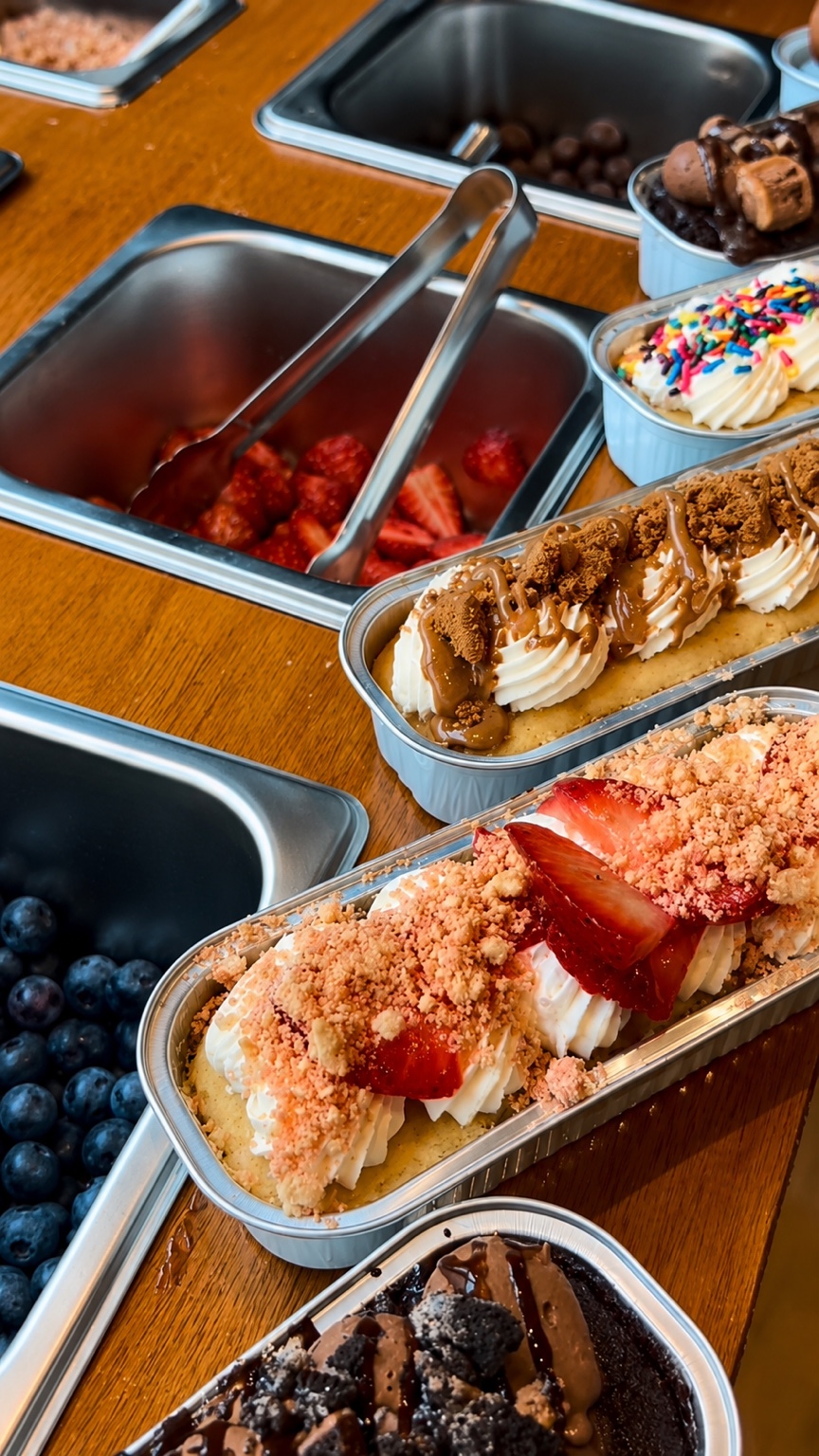 Individual mini cakes with cream, fruit, sauces and dessert toppings